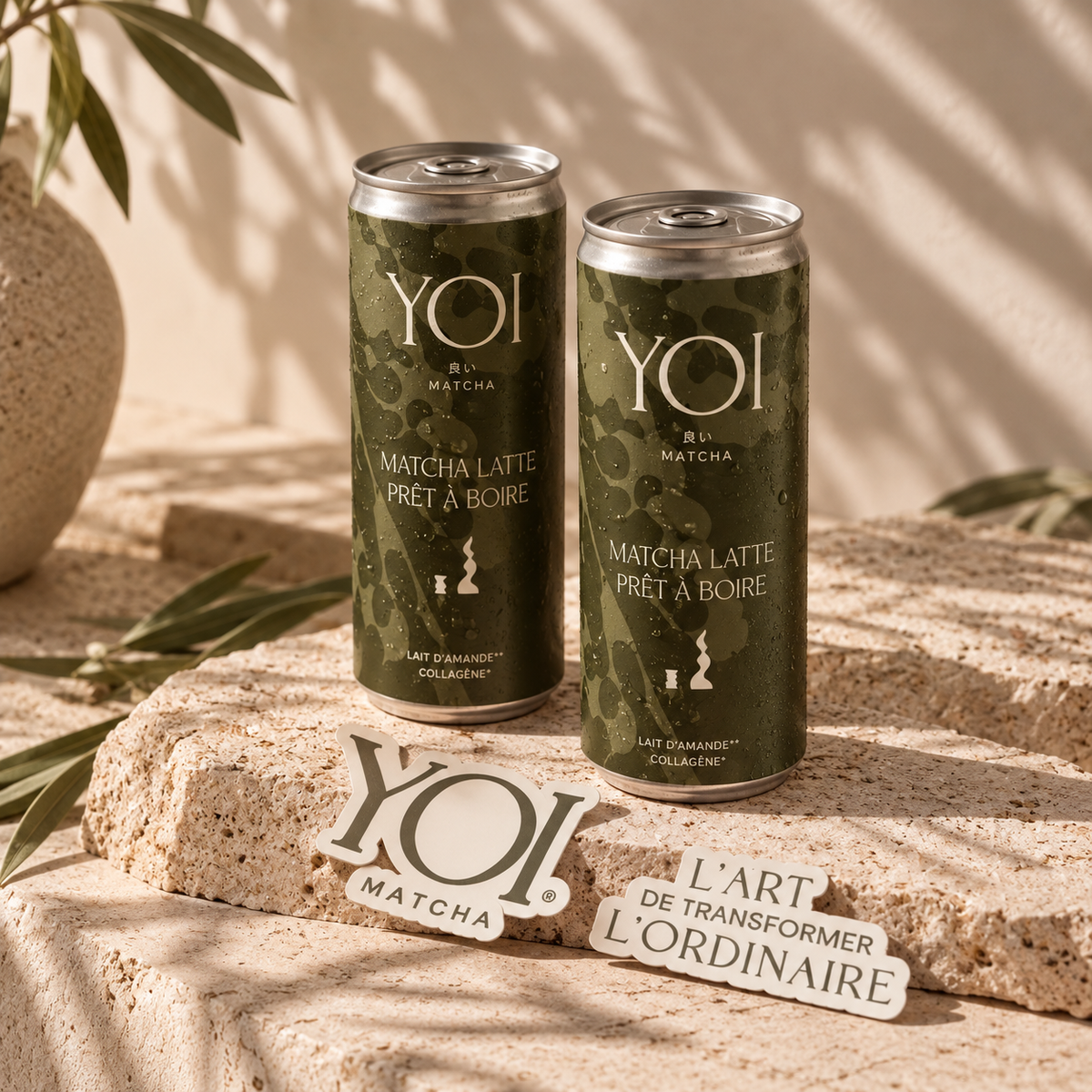 Canettes YOI de matcha latte prêt à boire au lait d'amande et collagène vegan, sur une pierre au soleil